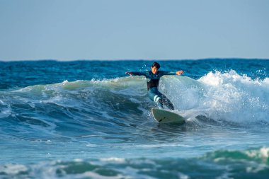 12/18/2018 Netanya, İsrail, sörfçü dalgası üzerinde sürmek ve günbatımında bir dalga üzerinde hile yapmak