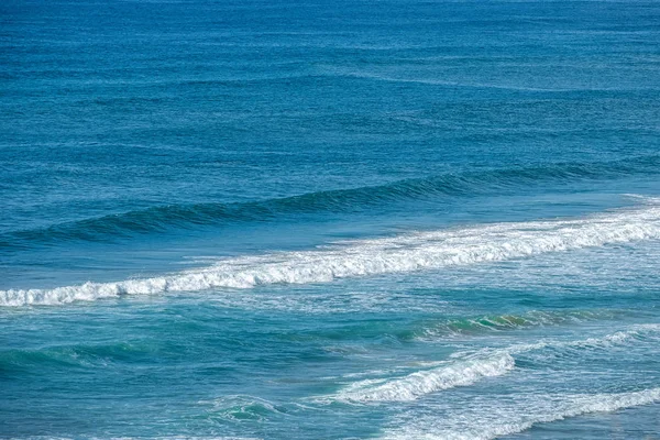 海の波が海岸への明るい青 — ストック写真