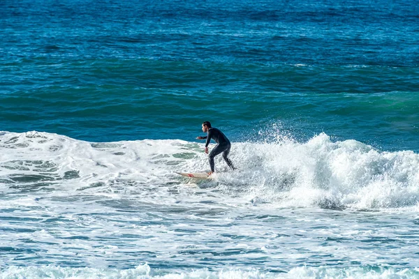 12/18/2018 Netanya, İsrail, sörfçü dalgası üzerinde sürmek ve günbatımında bir dalga üzerinde hile yapmak