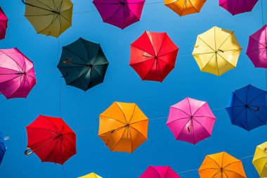 çok sayıda renkli şemsiyeler eski şehir merkezinde bir yaya caddesi üzerinde asılı. Yaz konsepti