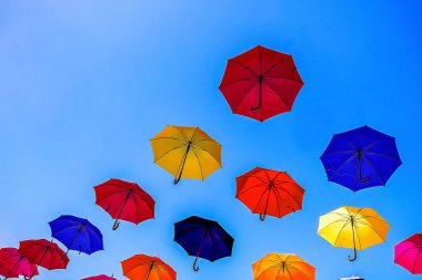 çok sayıda renkli şemsiyeler eski şehir merkezinde bir yaya caddesi üzerinde asılı. Yaz konsepti