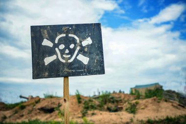 tehlike hakkında duyuran işareti önünde alanları mayınlı