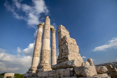 Amman Kalesi arka planı mavi gökyüzünde bulutlar ile dağ tepesinde Herkül Tapınağı kalıntıları eşsiz görünümü