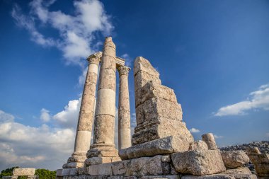 Amman Kalesi arka planı mavi gökyüzünde bulutlar ile dağ tepesinde Herkül Tapınağı kalıntıları eşsiz görünümü