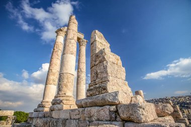 Amman Kalesi arka planı mavi gökyüzünde bulutlar ile dağ tepesinde Herkül Tapınağı kalıntıları eşsiz görünümü