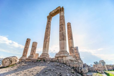 Amman Kalesi arka planı mavi gökyüzünde bulutlar ile dağ tepesinde Herkül Tapınağı kalıntıları eşsiz görünümü