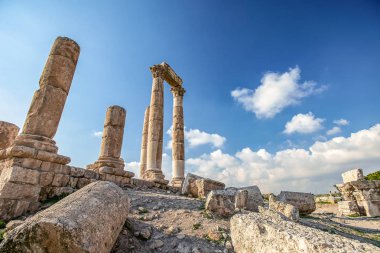 Amman Kalesi arka planı mavi gökyüzünde bulutlar ile dağ tepesinde Herkül Tapınağı kalıntıları eşsiz görünümü