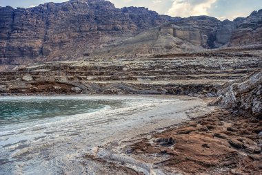 gün batımında ve dalgalar olmadan ölü deniz kıyısında tuzlu su yüzeyine