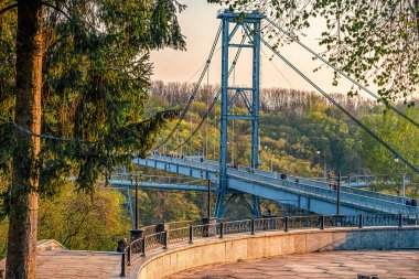 üzerinde yürüyen birçok kişi ile Nehir Teteriv üzerinde yaya köprüsü asılı