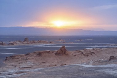 unsurpassed landscapes of sandy rocks with sunset above the desert in Lut desert,hottest desert in the world, also known like Kalut Desert clipart