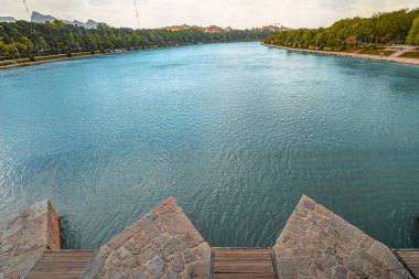 İsfahan, İran'daki Khaju Köprüsü'nde parlak mavi ve bordo su ile Zayandeh Nehri üzerinde Breakwave