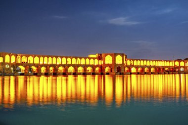 Zayandeh nehri üzerindeki Khaju Köprüsü, alacakaranlıkta ışıklarla dolu, baraj olarak da hizmet veriyor.