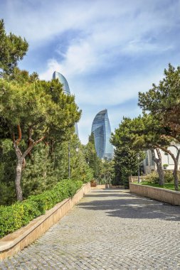05/05/2019 Bakü, Azerbaycan, Alev Kuleleri'nin güzel manzarası, Bakü'nün ikonik binaları, ağaçların iğne yapraklı koridorundan manzara