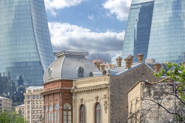 Bakü'nün Icherisheher eski kentinin dar sokaklarından sokak manzarası, geleneksel ev sonları ve modern Alev kuleleri manzaralı tarihi merkezci