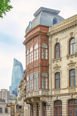 Bakü'nün Icherisheher eski kentinin dar sokaklarından sokak manzarası, geleneksel ev sonları ve modern Alev kuleleri manzaralı tarihi merkezci