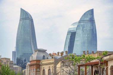 Bakü'nün Icherisheher eski kentinin dar sokaklarından sokak manzarası, geleneksel ev sonları ve modern Alev kuleleri manzaralı tarihi merkezci