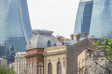 Bakü'nün Icherisheher eski kentinin dar sokaklarından sokak manzarası, geleneksel ev sonları ve modern Alev kuleleri manzaralı tarihi merkezci