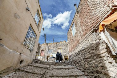 Doğu Azerbaycan Eyaleti'nde Kandovan'da geleneksel İran antik mağara köyü troglodyte avlusu ve iç görünümü. İran. Tebriz şehri yakınlarında. Türkiye'de köy gibi görünüyor. merdivenlerden çıkan iki İranlı kadın