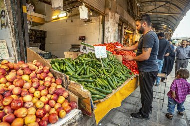 05/10/2019 Kerman, İran, Kerman Eyaleti, sebze pazarında taze sebze ve meyve ile ticaret sayacı ve satıcı