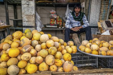 05/10/2019 Kerman, İran, Kerman Eyaleti, sebze pazarında taze kavun ve Pakistanlı bir satıcı ile bir ticaret sayacı