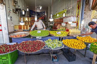 23/05/2019 Tebriz, İran, Doğu Azerbaycan Eyaleti, sebze pazarında satıcı taze meyve satın almak için yoldan geçenleri davet ediyor