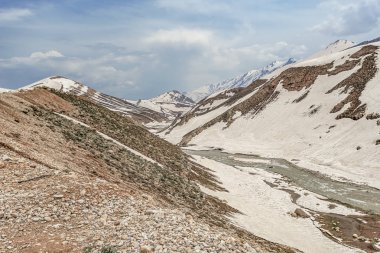 Parlak turkuaz nehir İran'ın karlı dağlarüzerinden akar, çok uzak olmayan Chelgerd i kasabasından
