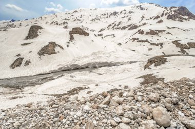 Parlak turkuaz nehir İran'ın karlı dağlarüzerinden akar, çok uzak olmayan Chelgerd i kasabasından