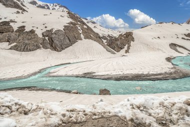 Parlak turkuaz nehir İran'ın karlı dağlarüzerinden akar, çok uzak olmayan Chelgerd i kasabasından
