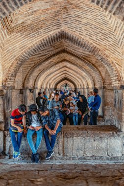 05-18-2019 İsfahan Eyaleti, İran, Khaju Köprüsü'nün altında kemerler içinde oturan ve gölgede dinlenen İran halkı