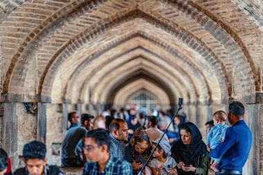 05-18-2019 İsfahan Eyaleti, İran, Khaju Köprüsü'nün altında kemerler içinde oturan ve gölgede dinlenen İran halkı
