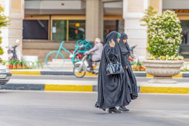 18/05/2019 İsfahan Eyaleti, İran, İranlı kadınlar tüm vücudu örten geleneksel kıyafetlerle cadde boyunca gidiyor