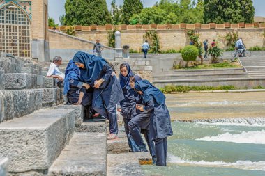 19/05/2019 İsfahan, İsfahan Eyaleti, İran, Khaju Köprüsü'nün merdivenlerinde oturan İranlı kız öğrenciler gülerek
