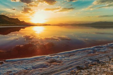 beautiful landscape and sunset with sky reflection over salty Lake Maharlu in Iran, Fars Province near Shiraz city, with incredibly red water like blood clipart