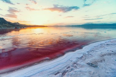 beautiful landscape and sunset with sky reflection in water over salty Lake Maharlu in Iran, Fars Province near Shiraz city, with incredibly red water like blood clipart