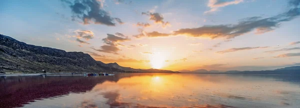 İran'da tuzlu Maharlu Gölü üzerinde gökyüzü yansıması ile güzel manzara ve gün batımı, Şiraz şehir yakınlarındaki Fars Eyaleti, kan gibi inanılmaz kırmızı su ile