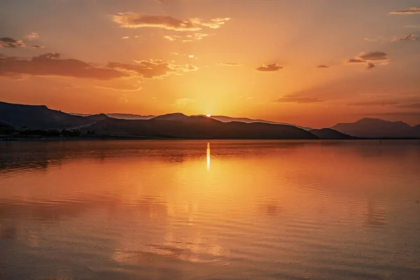 beautiful landscape and sunset with sky reflection in water over salty Lake Maharlu in Iran, Fars Province near Shiraz city, with incredibly red water like blood