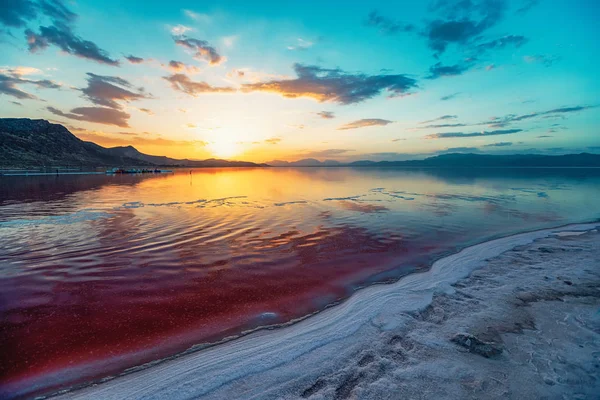 beautiful landscape and sunset with sky reflection over salty Lake Maharlu in Iran, Fars Province near Shiraz city, with incredibly red water like blood