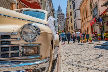 26.05.2019 İstambul, Galata Kulesi'nin geçişi ve İstanbul'un Avrupa yakasının en turistik ve ünlü simgesi olan retro otomobil Cadillac 1947'nin manzarası Büyük Hendek Cd Caddesi'dir. bir kartpostal olarak turist görüntü. selfie yeri