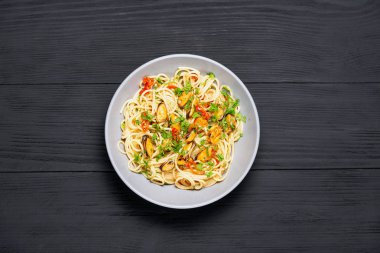 Midye Marinara ile Makarna Spagetti deniz ürünleri, İtalyan makarna tipik yemek. üst görünüm. metin için bir yer ile siyah bir arka plan üzerinde, kopyalama alanı