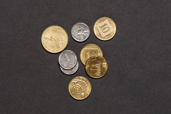 Different israeli new shekel coins stacked on black background