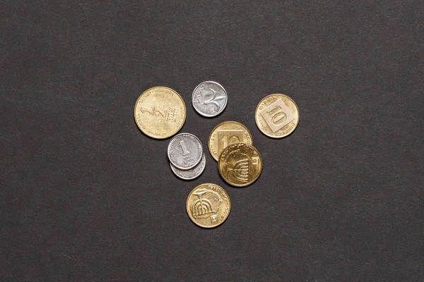 Different israeli new shekel coins stacked on black background