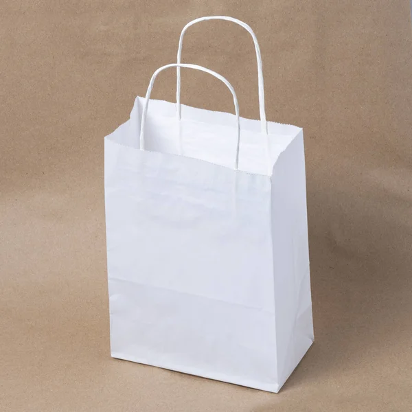 昼食や食べ物や茶色のペーパークラフトの背景に購入のためのリサイクルブランククラフト紙ショッピング白いバッグのモックアップ — ストック写真
