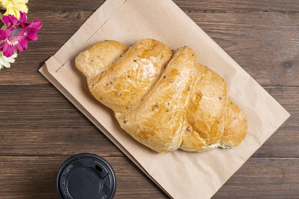 Croissant Papírové Tašce Dřevěném Podkladu Papírovým Jednorázovým Šálkem Kávy Koncepce — Stock fotografie