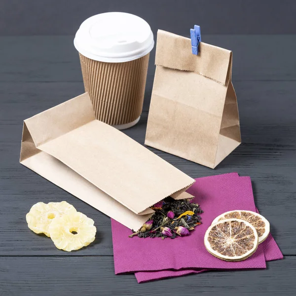 black Ceylon tea in a food paper eco bag on a black wooden background. concept of eco packaging