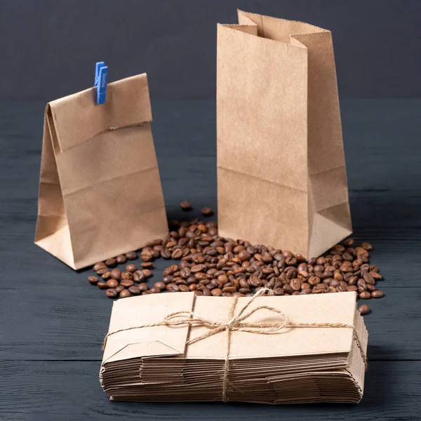 roasted coffee beans in food paper bag on wooden background. concept of eco packages of recyclables