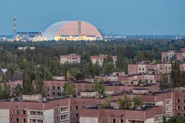 Terk edilmiş Pripyat umuduyla Çernobil nükleer enerji santralinin ışıklarıyla akşam vakti yeni güvenlik kemerinin görüntüsü. NSF, güvenli kapatma işi için yeni bir lahit.