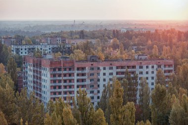 Gündoğumunda kayıp şehir Pripyat 'ın hava manzarası. Ağaçlarla kaplı bir sürü boş beton zemin. Pripyat, Çernobil nükleer santralindeki kazadan sonra 33 yıl boyunca boşaldı.