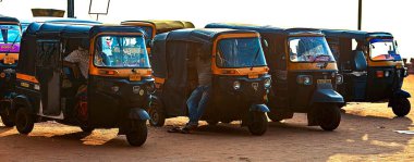 12 / 27 / 2019 Gokarna. Karnataka, Hindistan, otomobil çekçekçekleri Gokarna Caddesi 'nde arka arkaya park edilmiş. Rickshaw 'lar Hindistan' ın en popüler ve en ucuz taksi taşımacılarıdır.