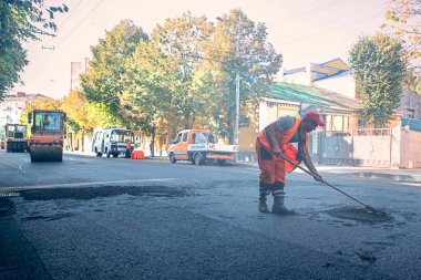08.24.2019 Zhytomyr. Ukrayna. Bir yol servis robotu şehir merkezindeki bir yola yeni bir asfalt koyuyor. el emeği kavramı