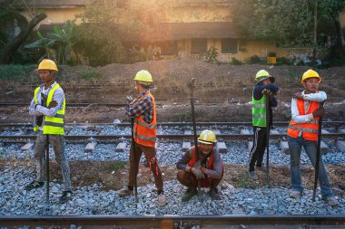 01 / 22 / 2020 Myanmar (Burma) Yangon, Birmanyalı bir demiryolu ekibi gün batımındaki demiryolu raylarını hatırlatıyor. Burma Demiryolu, Ölüm Demiryolu olarak da bilinen en yavaş demiryoludur. Myanmar 'ı keşfet